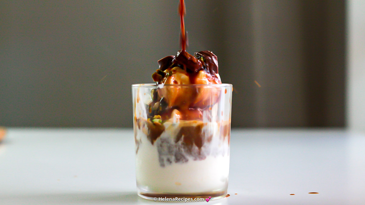 Pouring chocolate on top of the Vanilla Affogato served in a glass cup