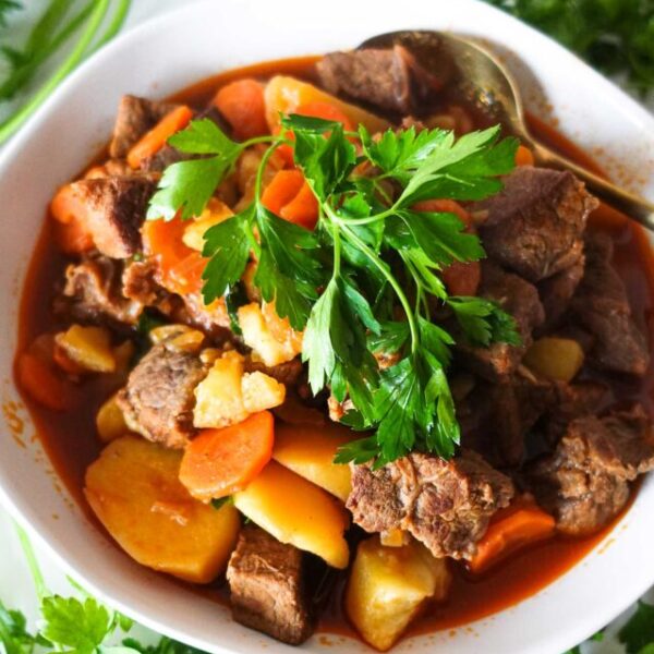 A bowl beef stew with fresh parsley.