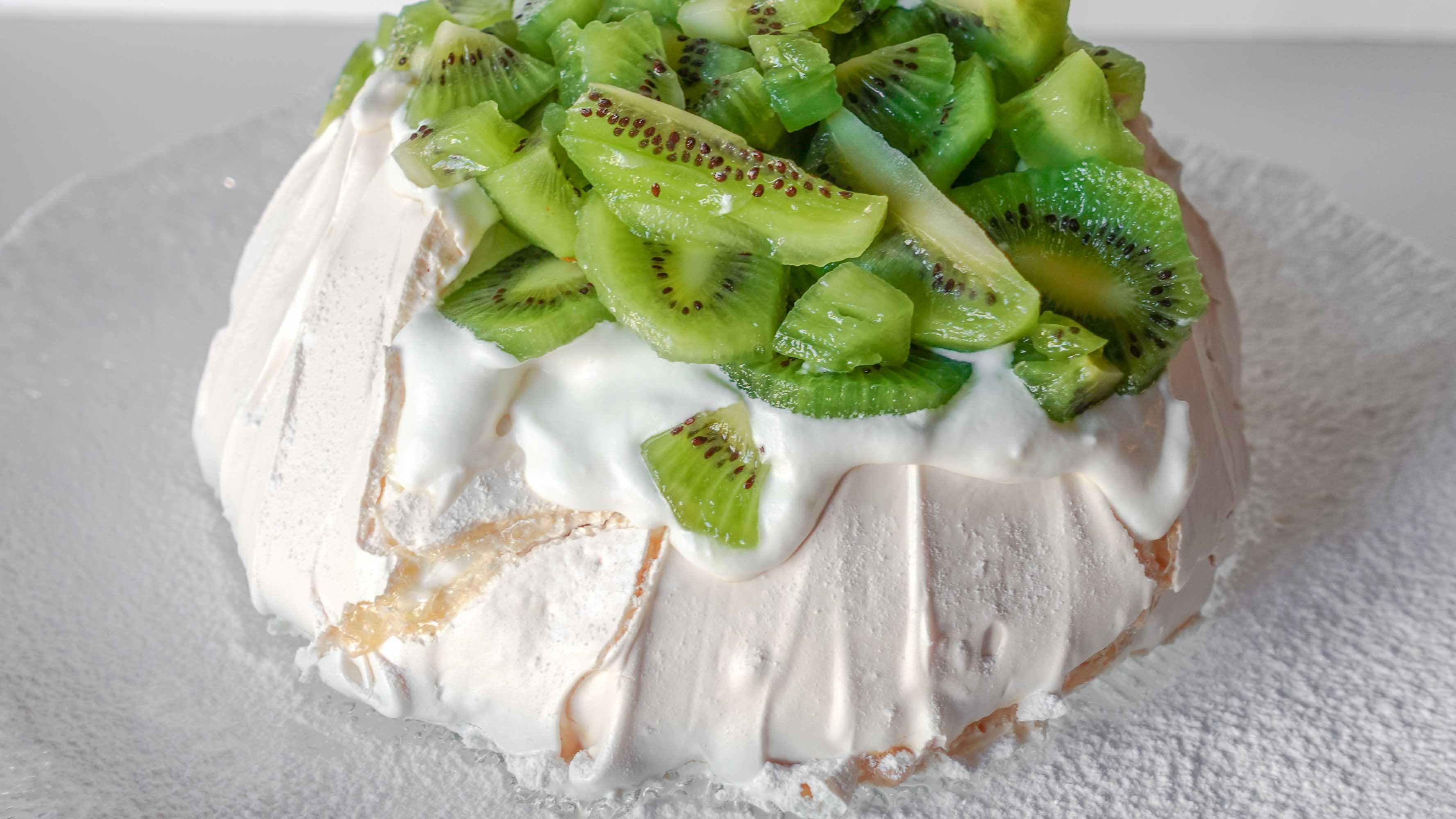 Amazing Kiwi Pavlova on a plate with icing sugar