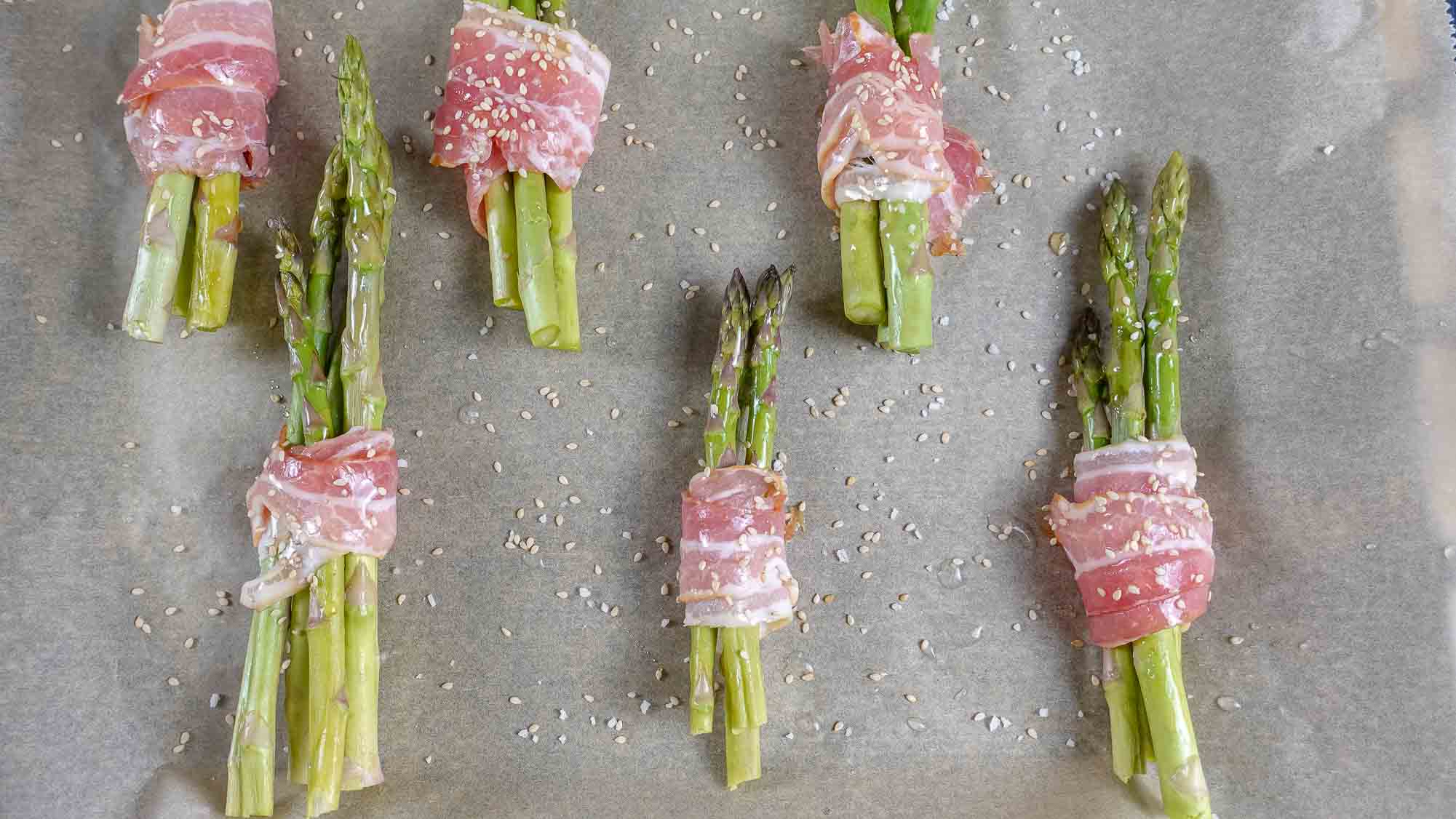 Bacon Wrapped Asparagus Recipe on a baking paper on a tray.